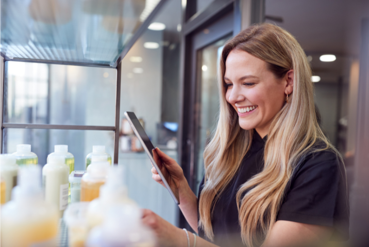 A female stylist using Salon Management Software to order salon stock on a tablet